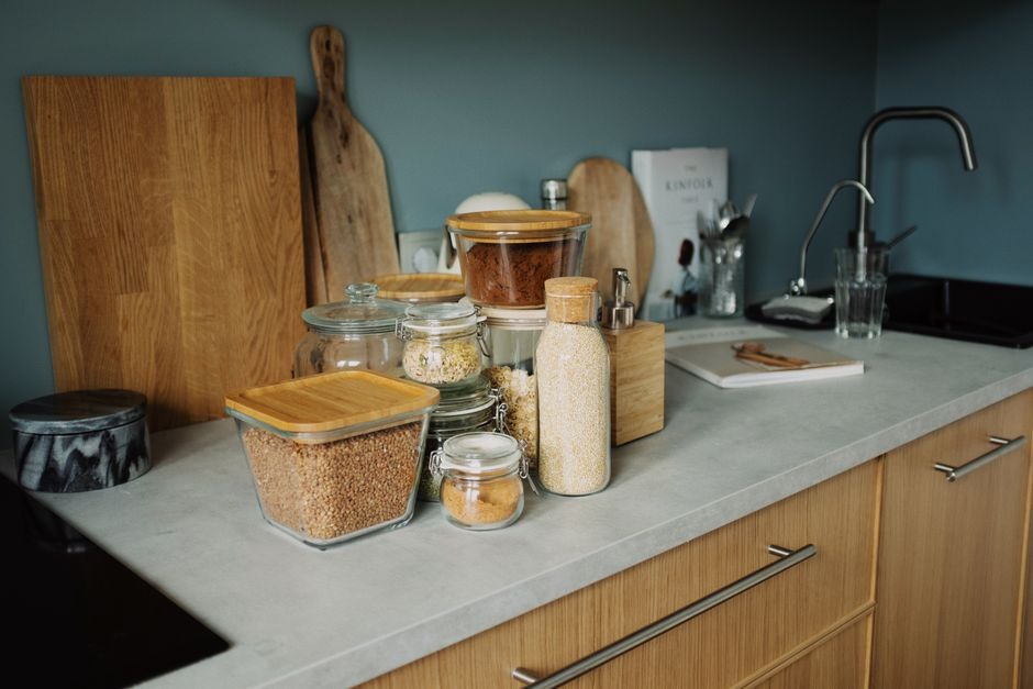 An organized kitchen counter with jars and wooden boards used for everyday cooking.
