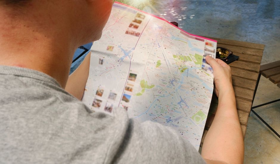 A traveler studies a city map before a neighborhood walk.