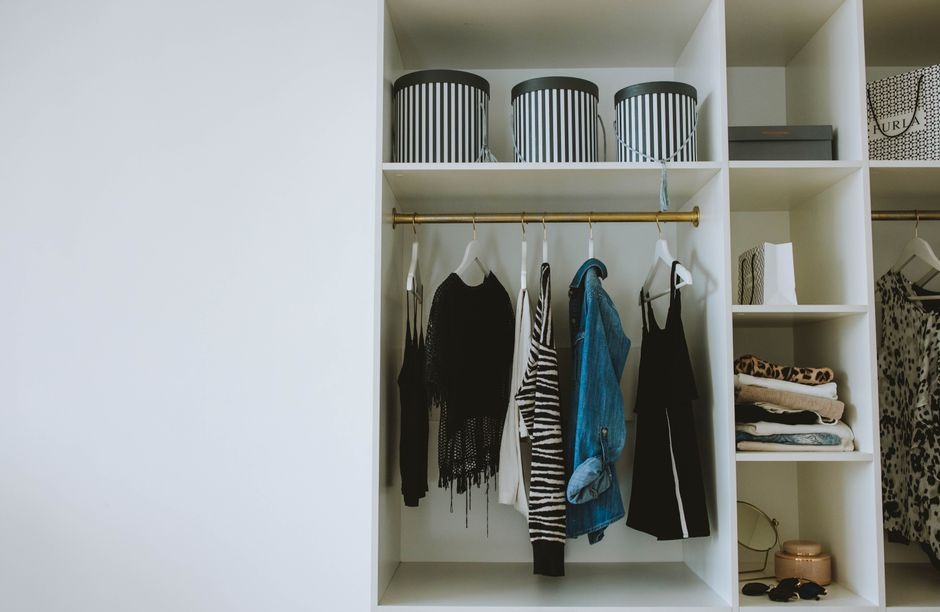 A neatly organized wardrobe with hanging clothes and folded garments.